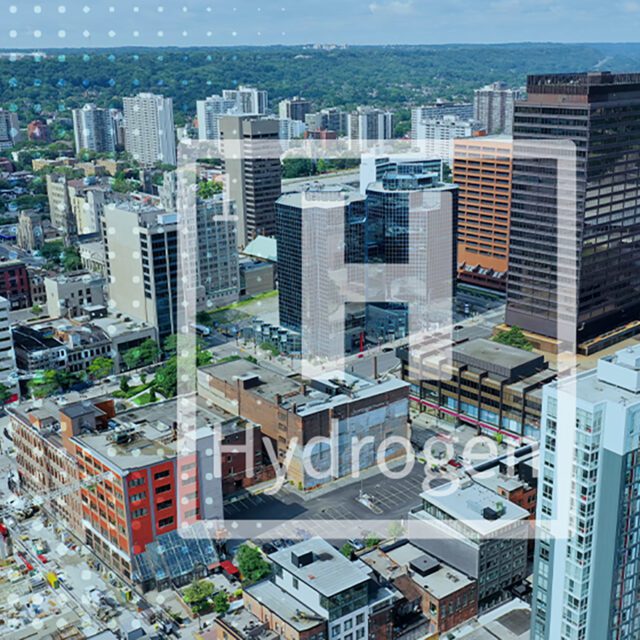 'H' for hydrogen superimposed over an aerial view of a city.